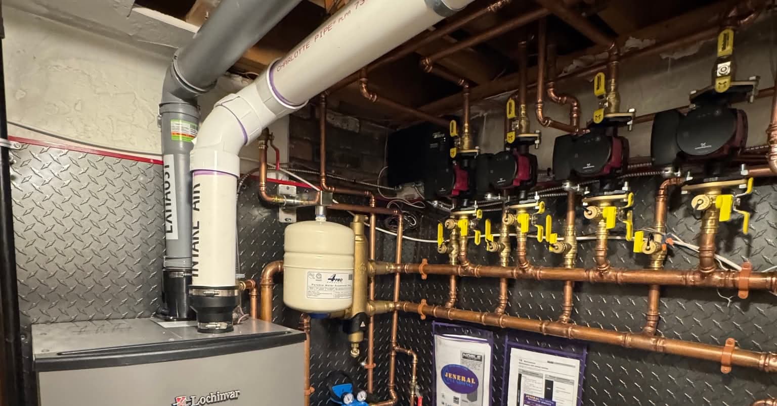 Lochinvar boiler with copper hydronic piping and circulator pumps in a utility room