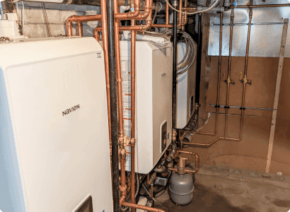 Wall-mounted heating equipment above connected copper piping