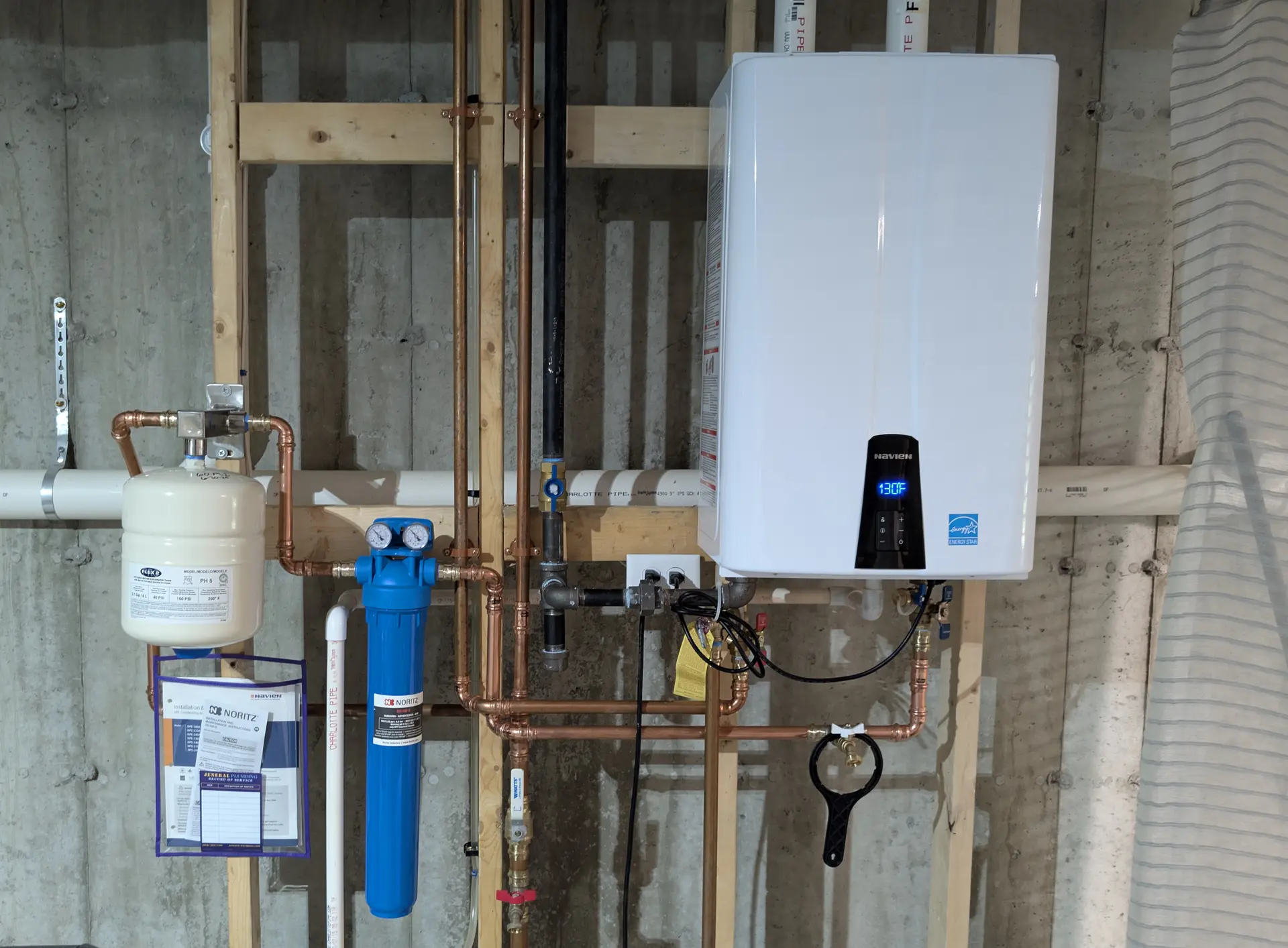 ENERGY STAR Navien condensing tankless water heater with sediment filtration and expansion tank installed by Jeneral Plumbing in a Massachusetts basement