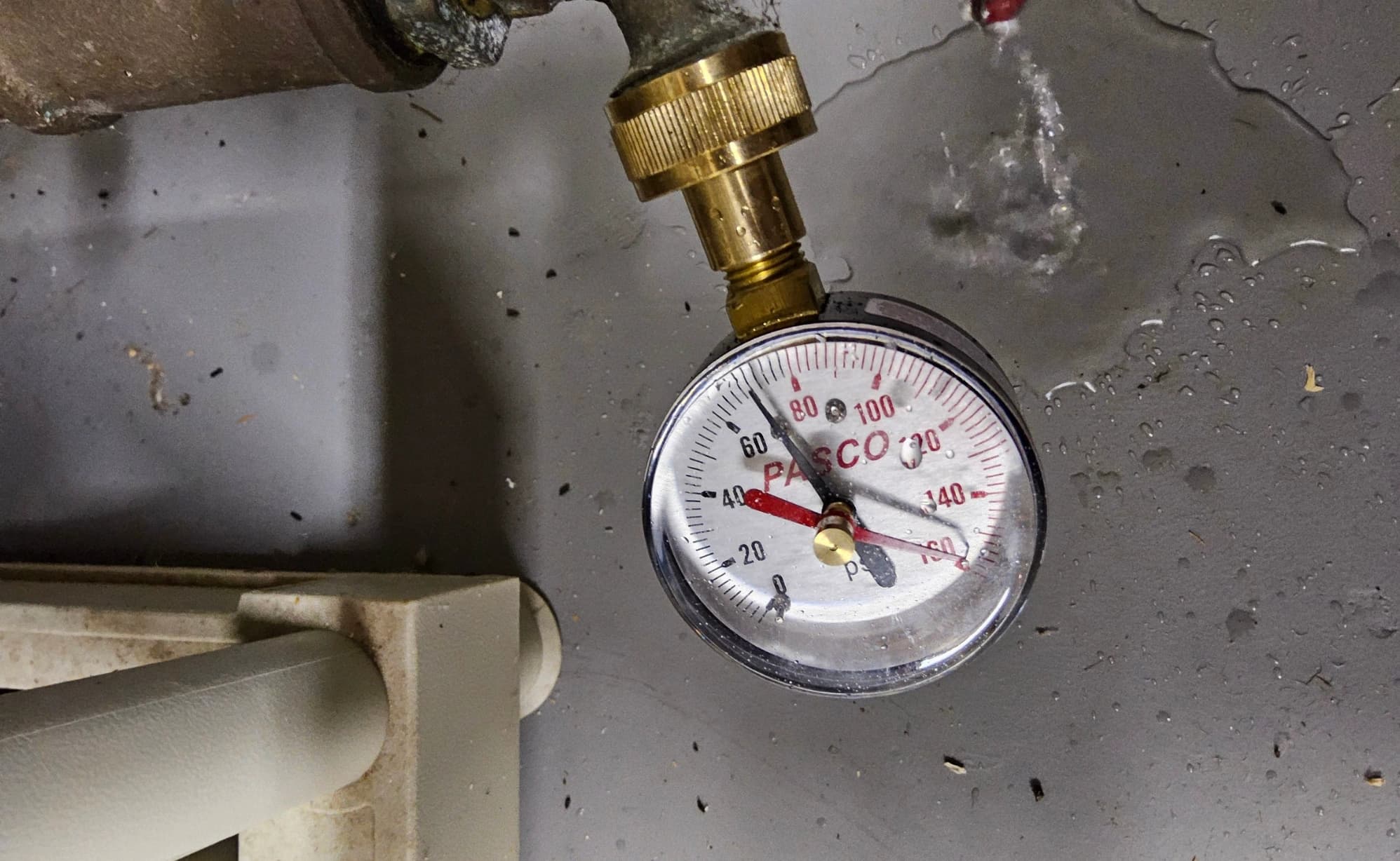 Pressure gauge on a brass threaded fitting.